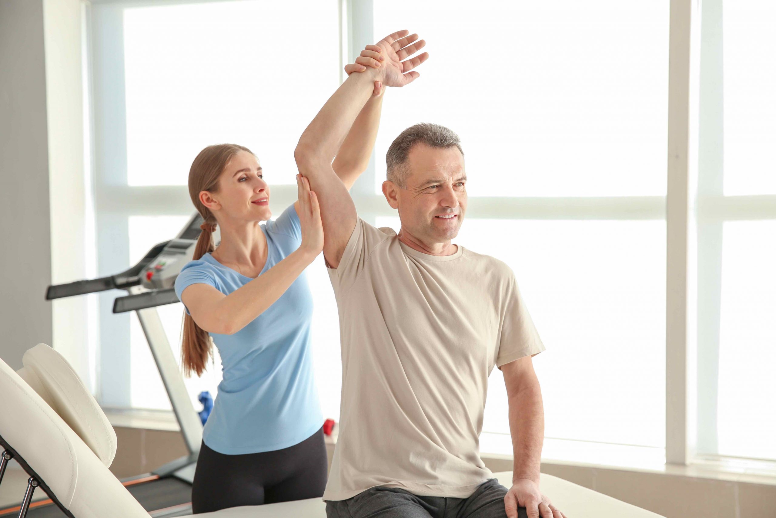 Physiotherapist working with mature patient in rehabilitation center